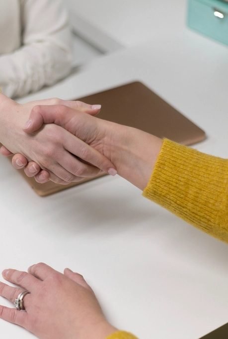 Client and advisor shaking hands across a desk
